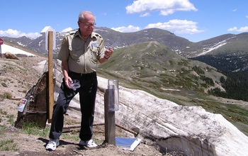 citizen scientist with rain gauge in Rocky Mountains